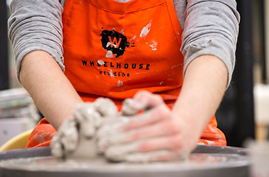 An artist spinning pottery at Wheelhouse Studios